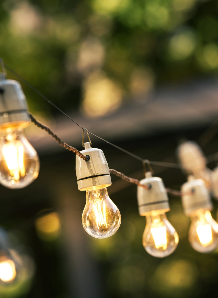 Outdoor string lights hanging on a line in backyard