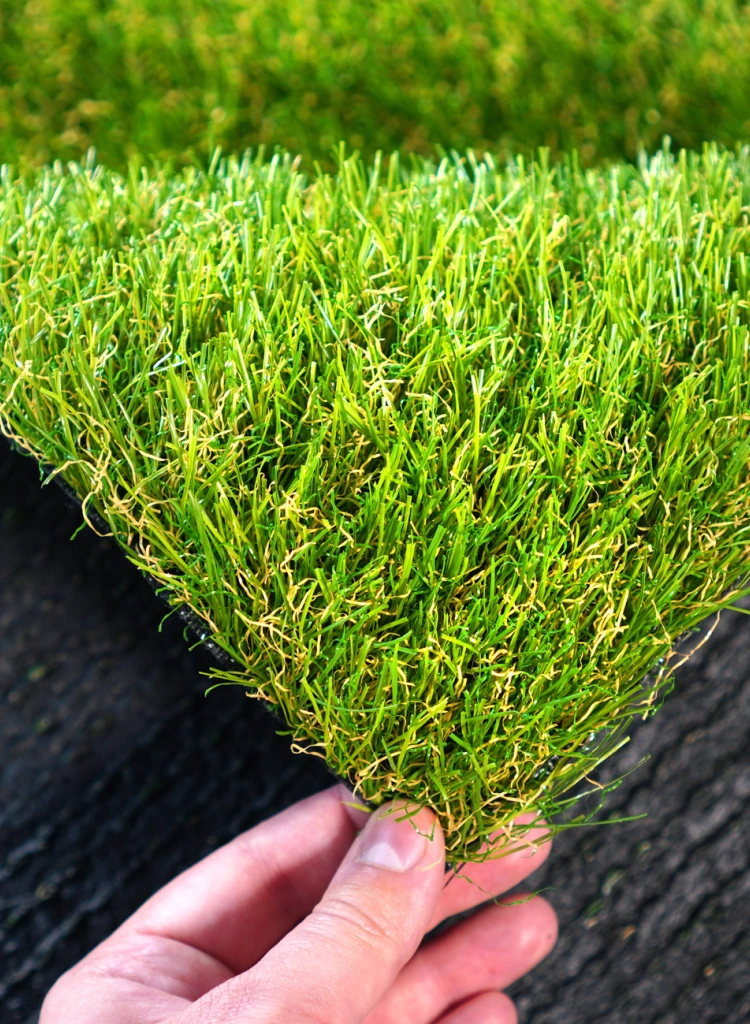 Hand holding an artificial grass roll Greenering with an artificial turf