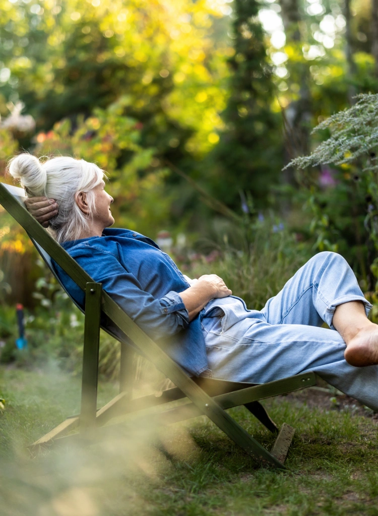 Woman in deck chair in garden at summer