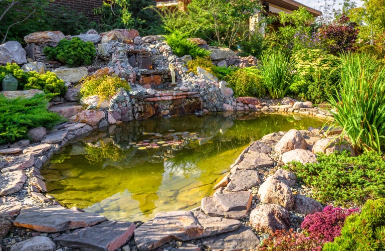 Landscape design of home garden close up Beautiful landscaping with small pond and waterfall