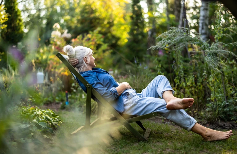 Woman in deck chair in garden at summer
